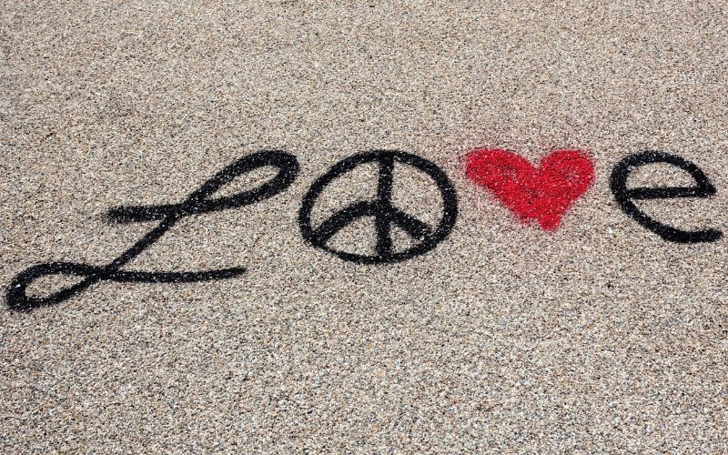 Love tagué au sol en noir, avec le "O" en peace&love et le "V" en coeur rouge.